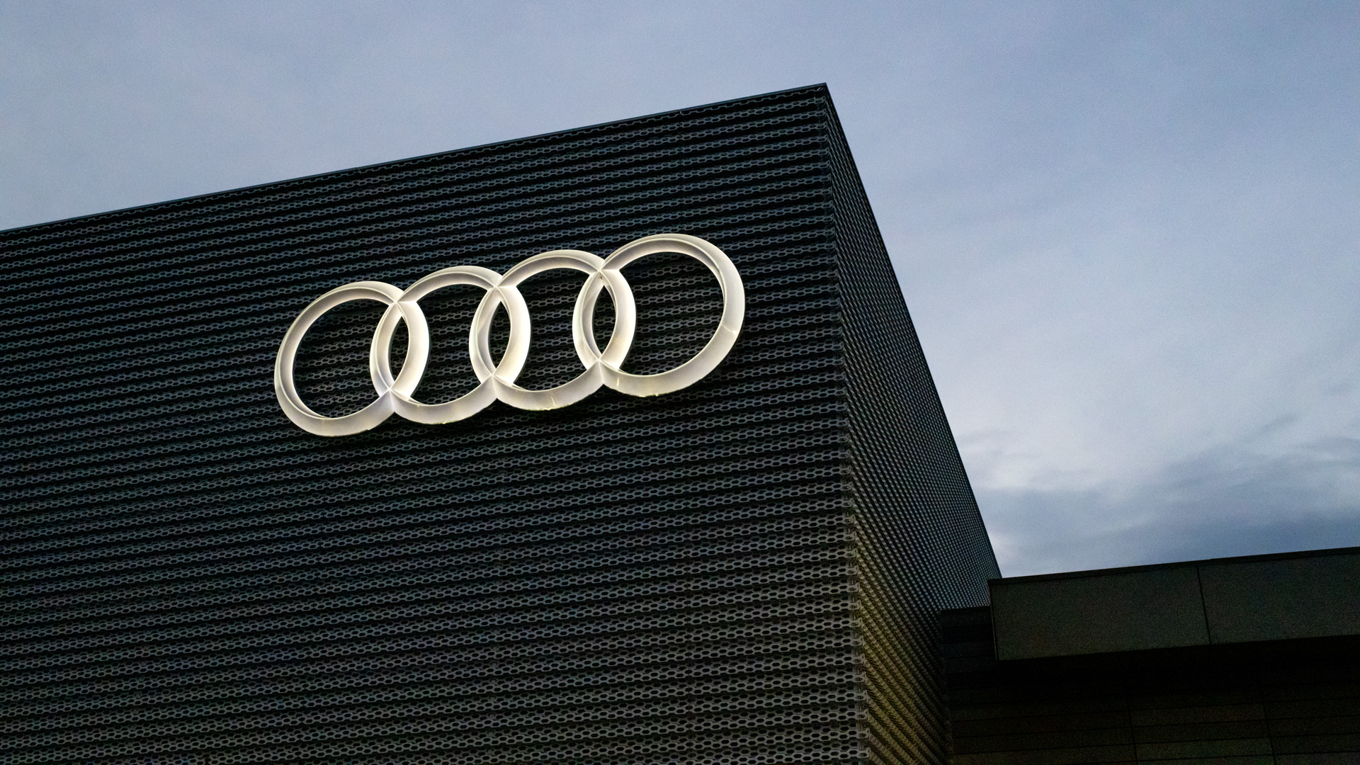 Close-up of the Audi rings on the outside of an Audi dealership.