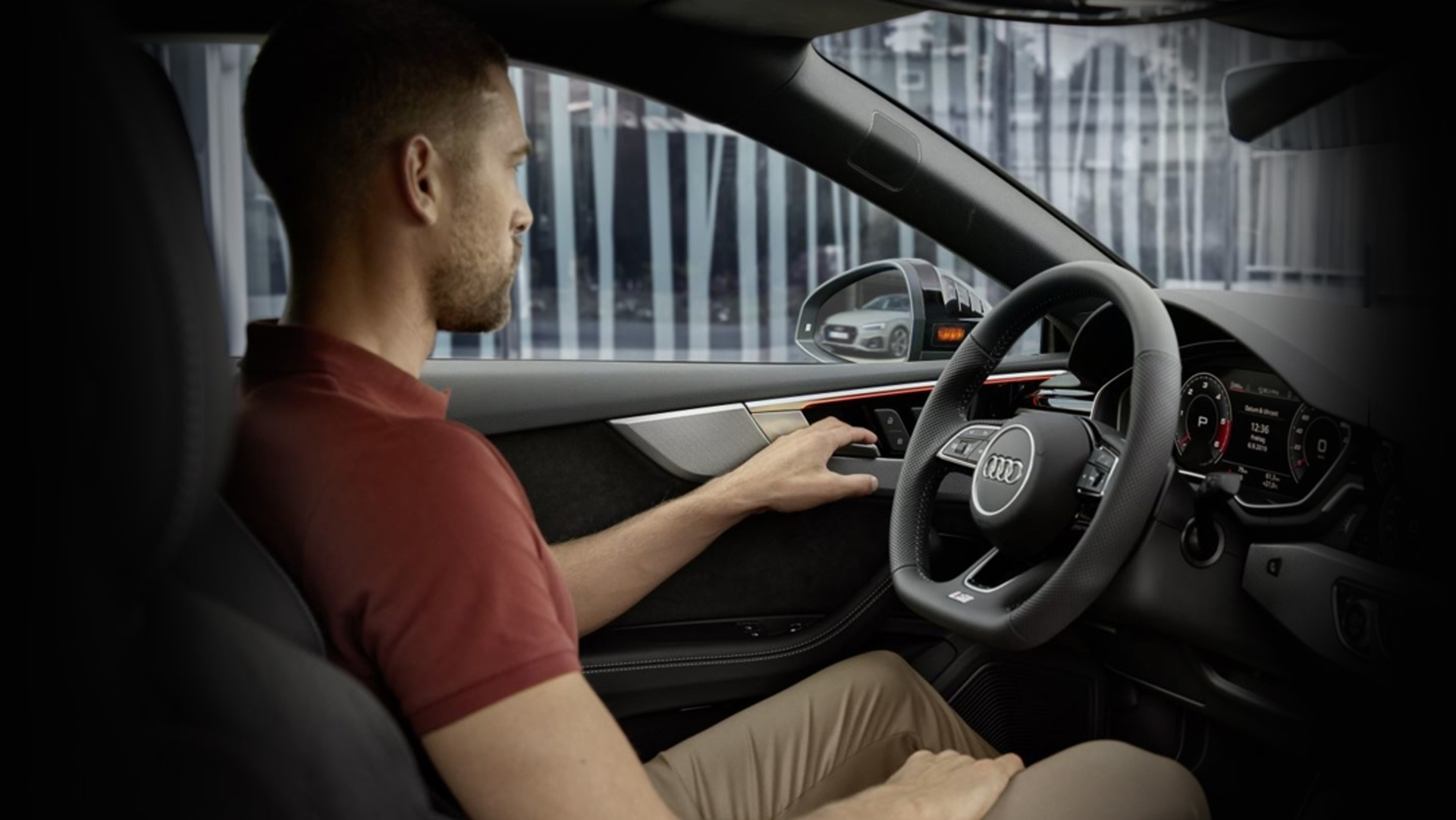 Interior view of a man driving an Audi. 